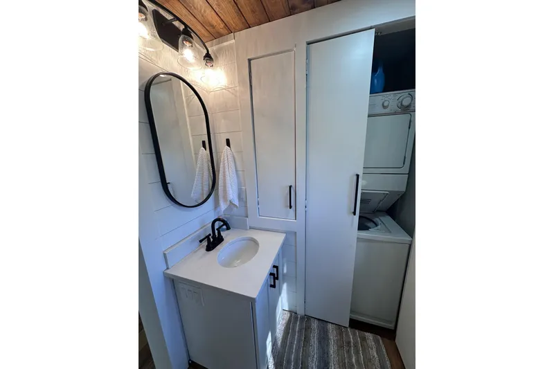 Slide: The Image of Compact bathroom with oval mirror, vanity, and stacked washer-dryer in 1996 Sumerset 16x83 houseboat. - 10