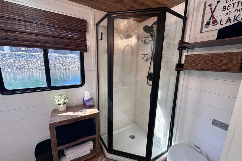 Slide: The Image of Modern bathroom in a 1996 Sumerset 16x83 houseboat with glass shower and lake view. - 11