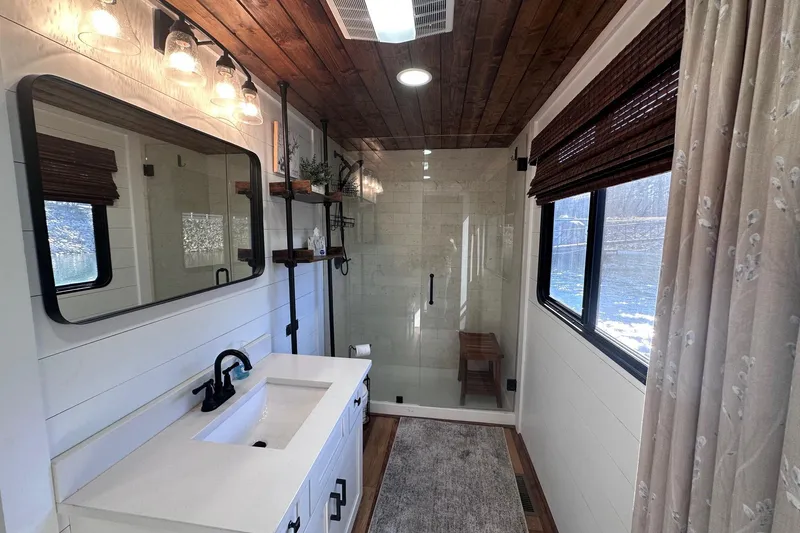 Slide: The Image of Modern bathroom in 1996 Sumerset 16x83 houseboat with wood accents and glass shower. - 13