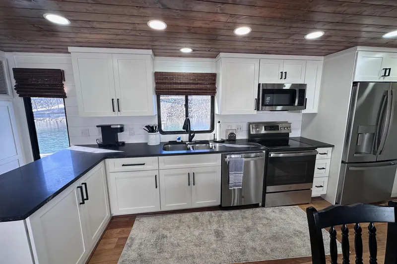 Slide: The Image of Modern kitchen in a 1996 Sumerset 16x83 houseboat with stainless steel appliances and wooden ceiling. - 4