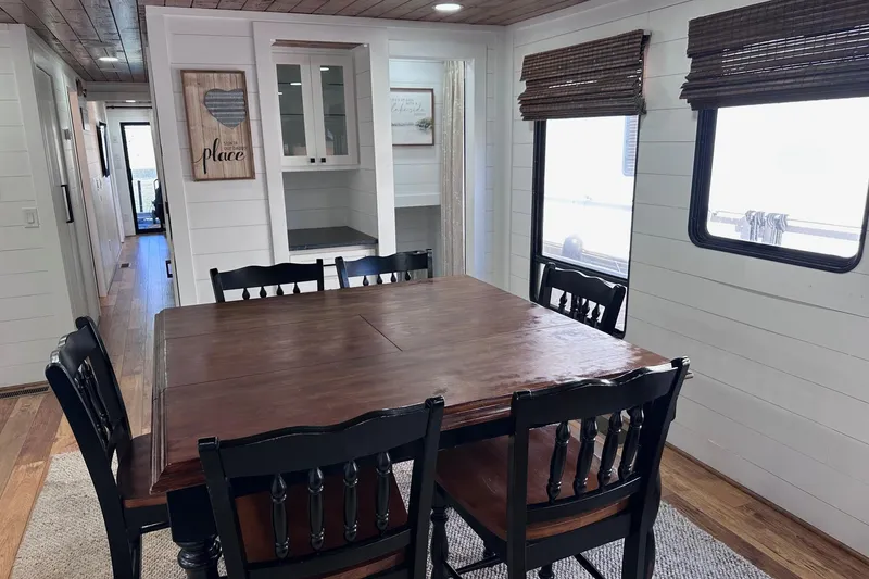 Slide: The Image of Dining area in a 1996 Sumerset 16x83 houseboat with wooden table and chairs. - 6