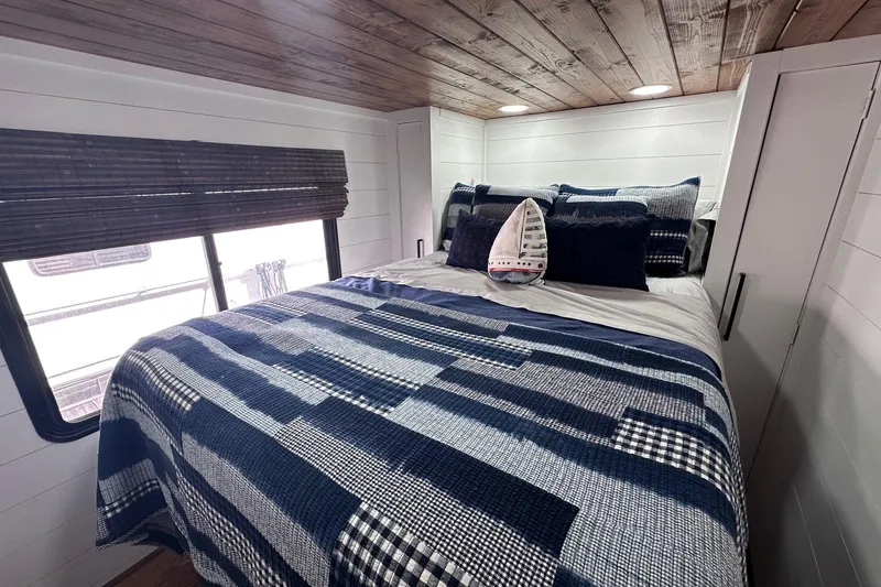 Slide: The Image of Cozy bedroom in 1996 Sumerset 16x83 houseboat with nautical-themed decor and wooden ceiling. - 7
