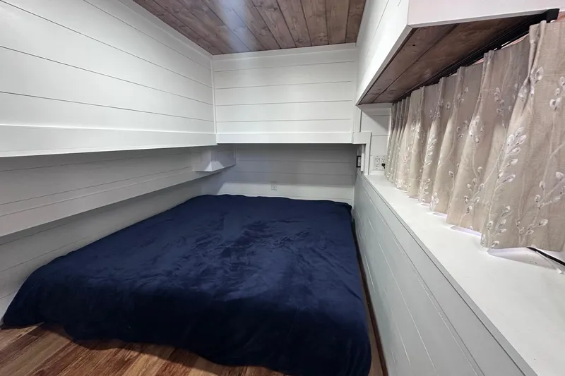 Slide: The Image of Cozy bedroom in 1996 Sumerset 16x83 houseboat with wood accents and navy bedding. - 8