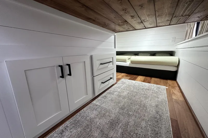 Slide: The Image of Cozy Sumerset 16x83 houseboat interior with white cabinets, wood ceiling, and bed, 1996 model. - 9