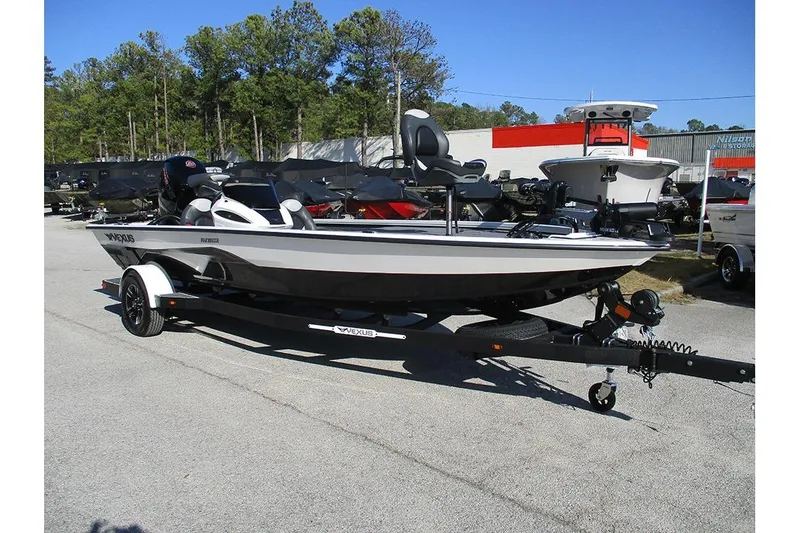 Slide: The Image of 2026 Vexus AVX 1980 boat on trailer, parked outdoors, surrounded by trees and other boats. - 3