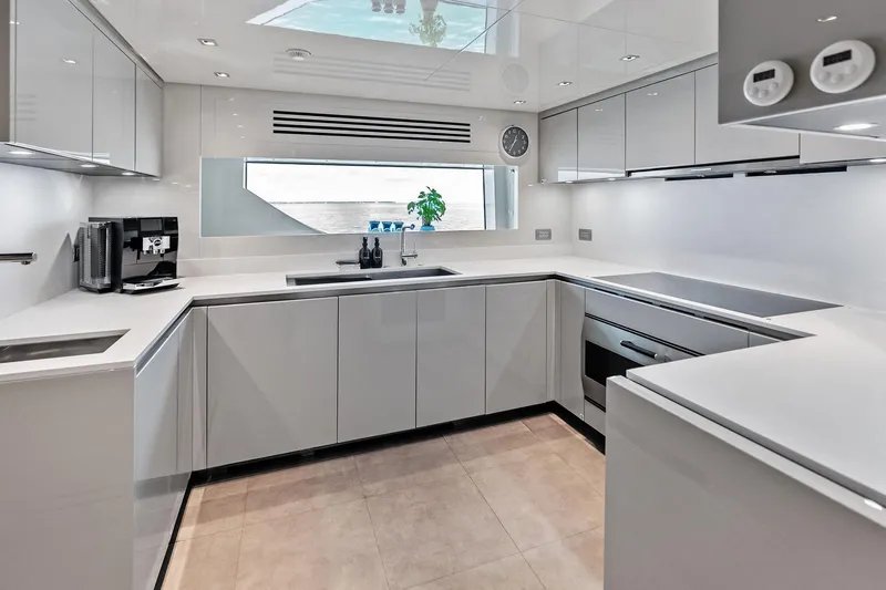 Slide: The Image of Modern kitchen interior on 2023 Sanlorenzo SD126 yacht, featuring sleek white cabinetry and appliances. - 32
