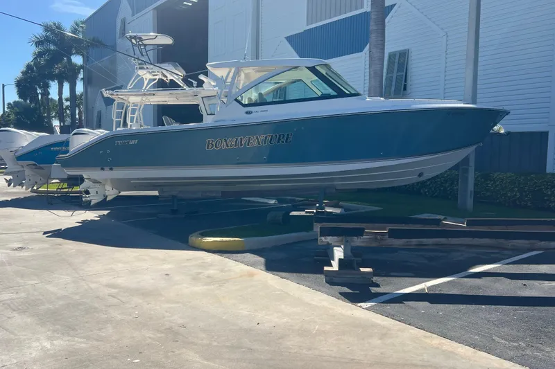 The Image of 2016 Pursuit DC 325 Dual Console boat on display outside a marina. - 0