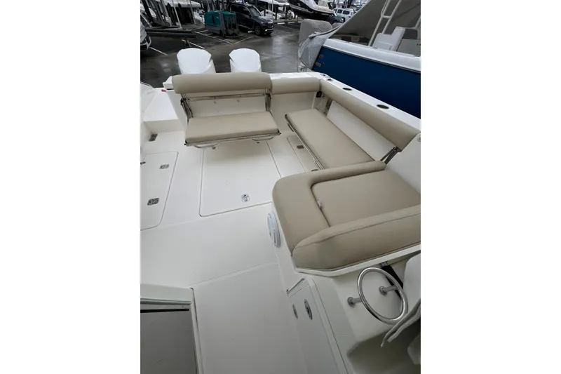 Slide: The Image of 2016 Pursuit DC 325 Dual Console boat interior with beige seating and spacious deck. - 2