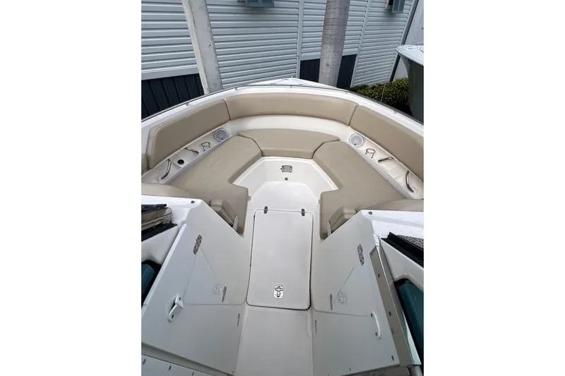 Slide: The Image of 2016 Pursuit DC 325 Dual Console boat interior with beige seating and storage compartments. - 3