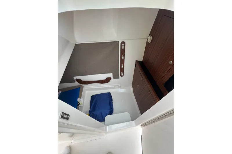 Slide: The Image of Interior cabin of 2016 Pursuit DC 325 Dual Console boat, featuring wood cabinetry and seating. - 7