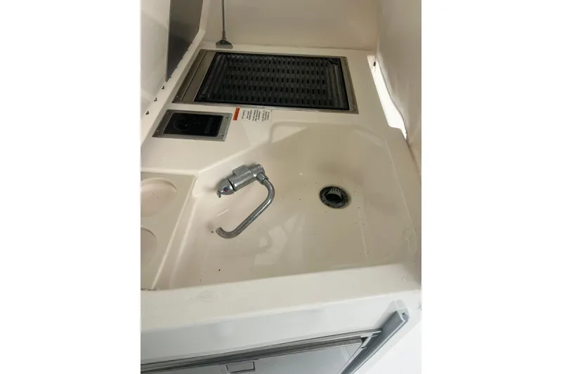 Slide: The Image of 2016 Pursuit DC 325 Dual Console boat sink and grill area. - 8