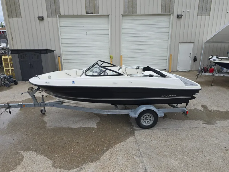 Slide: The Image of 2018 Bayliner VR4 Bowrider I/O on trailer, parked outside a garage. - 5
