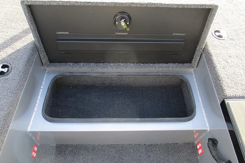 Slide: The Image of Open storage compartment in 2026 Vexus Defender 189 boat, featuring secure latch and carpeted interior. - 10