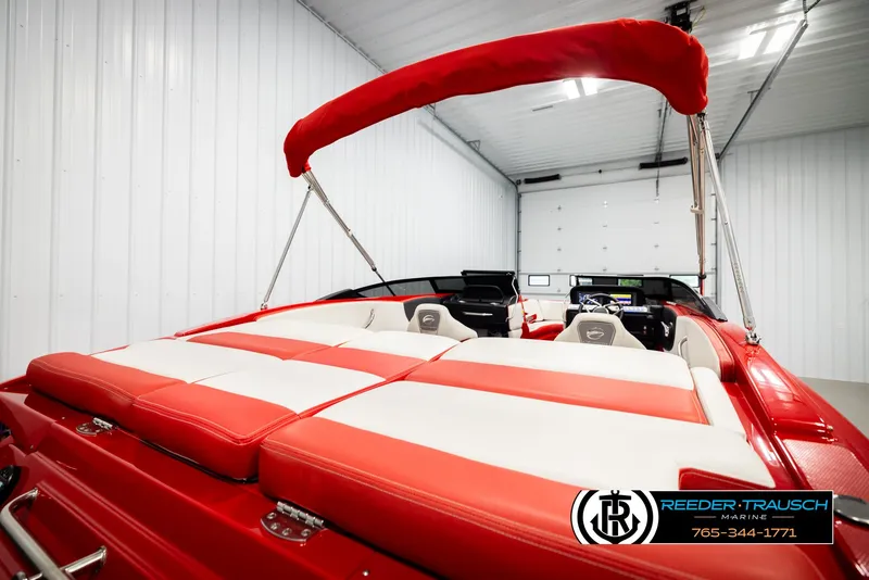 Slide: The Image of 2022 Crownline 220 LPX boat with red and white seating in a garage. - 23