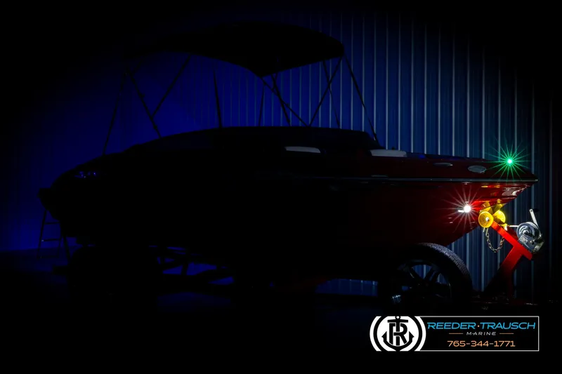 Slide: The Image of 2022 Crownline 220 LPX boat in dark setting with trailer lights illuminated. - 4