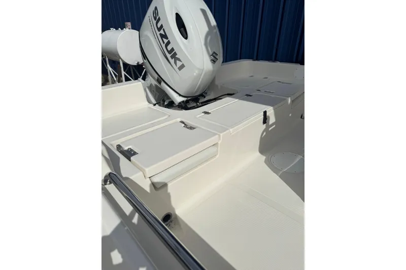 Slide: The Image of 2026 Bulls Bay 2200 boat with Suzuki outboard motor, white deck, and storage compartments. - 2