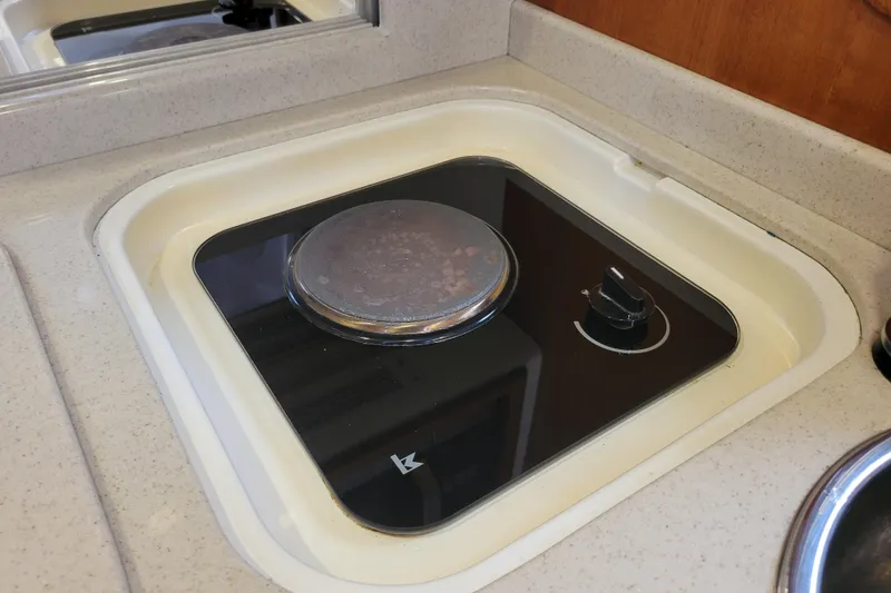 Slide: The Image of 1998 Cabo 31 Express boat stove in compact kitchen area. - 13