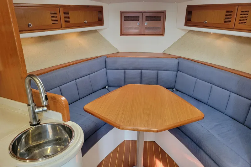 Slide: The Image of Interior of 1998 Cabo 31 Express with Tower, featuring cozy seating and wooden table. - 14