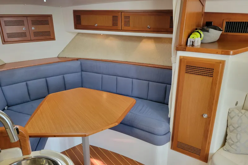 Slide: The Image of 1998 Cabo 31 Express interior with blue seating and wooden table. - 15