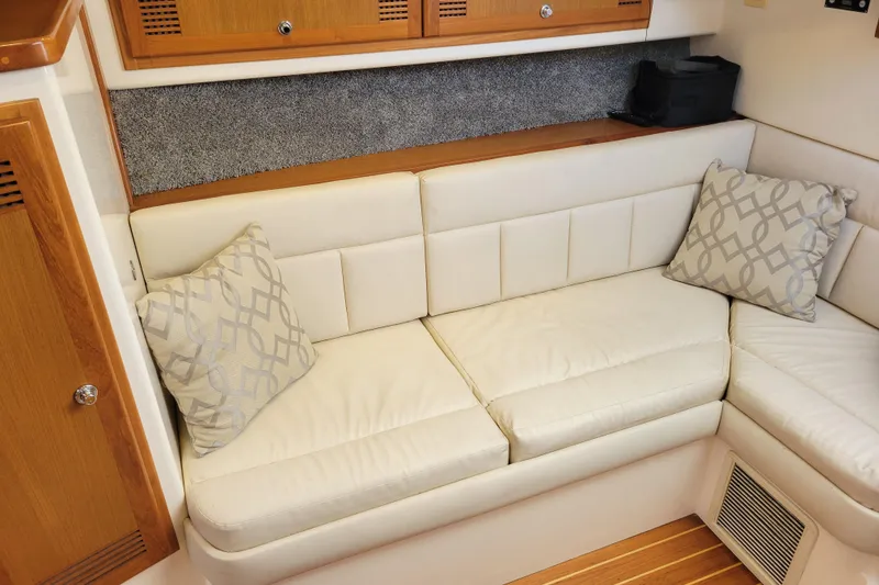 Slide: The Image of 1998 Cabo 31 Express interior with white leather seating and decorative pillows. - 18