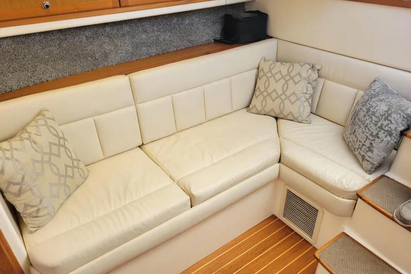 Slide: The Image of Luxurious interior of 1998 Cabo 31 Express with Tower, featuring cream leather seating and decorative pillows. - 19
