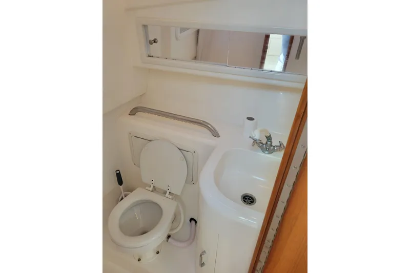 Slide: The Image of 1998 Cabo 31 Express boat bathroom with toilet, sink, and mirror. - 21