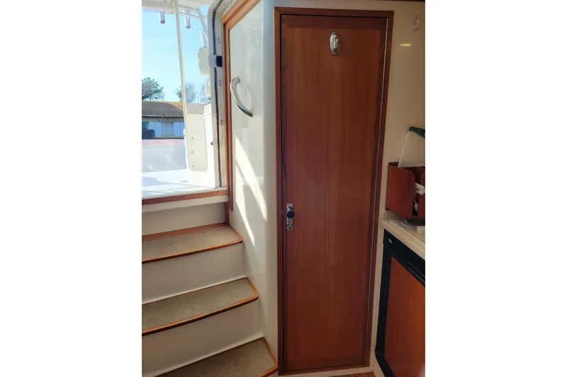 Slide: The Image of Interior view of 1998 Cabo 31 Express with Tower, featuring wooden door and stairs. - 23