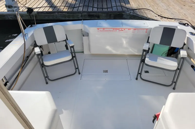 Slide: The Image of 1998 Cabo 31 Express boat deck with two folding chairs and fish ruler. - 25