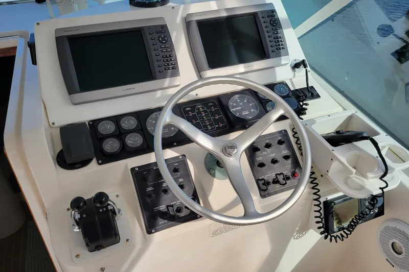Slide: The Image of Control panel of a 1998 Cabo 31 Express with Tower, featuring Garmin displays and steering wheel. - 4