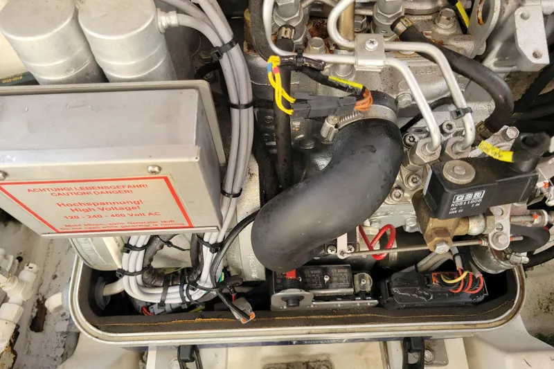 Slide: The Image of Engine compartment of a 1998 Cabo 31 Express with Tower, showing high voltage warning. - 41