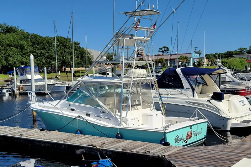 Slide: The Image of 1998 Cabo 31 Express with Tower docked at marina, clear blue sky. - 43