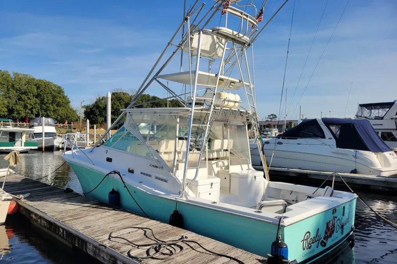 Slide: The Image of 1998 Cabo 31 Express with Tower docked at marina, clear sky background. - 44