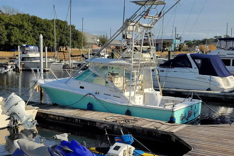 Slide: The Image of 1998 Cabo 31 Express with Tower docked at marina, surrounded by other boats. - 46