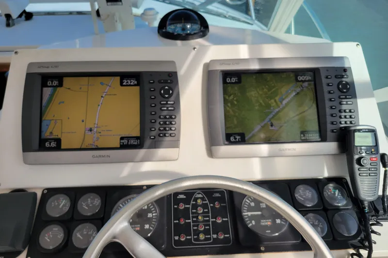 Slide: The Image of Control panel of a 1998 Cabo 31 Express with Tower, featuring Garmin navigation displays. - 5