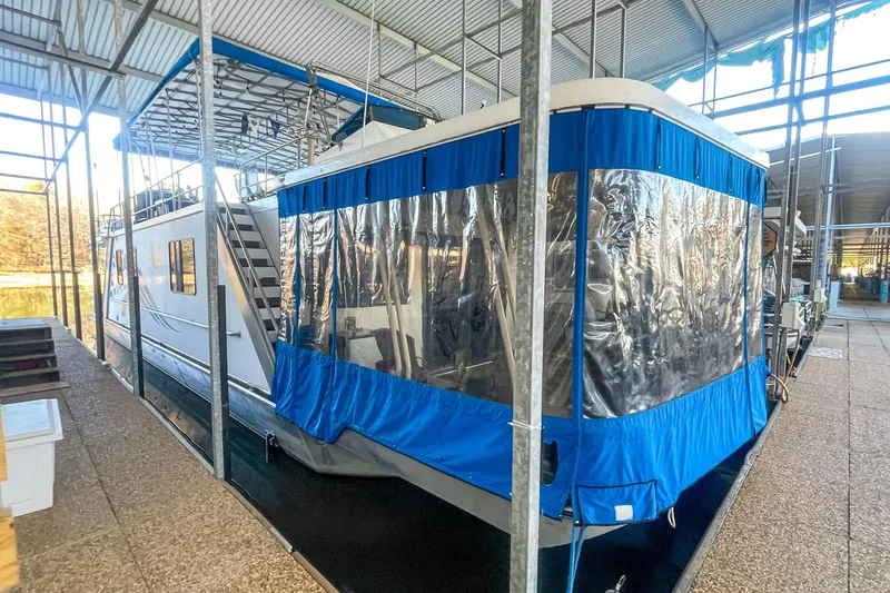 Slide: The Image of 1996 Lakeview 66 x 16 Widebody Houseboat docked under a covered marina. - 10