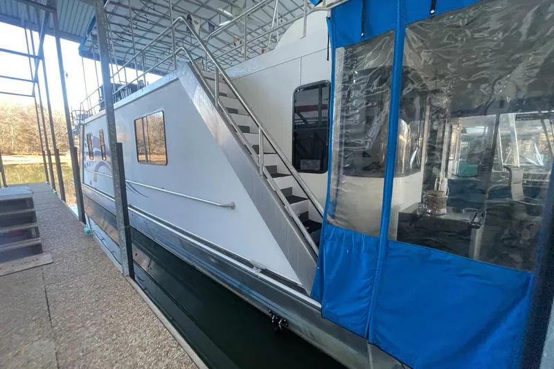 Slide: The Image of 1996 Lakeview 66 x 16 Widebody Houseboat docked with blue canopy. - 11