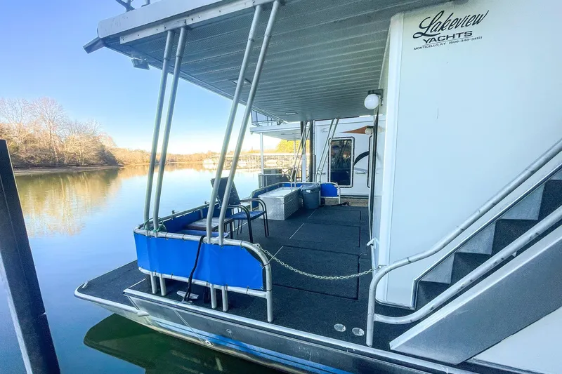 Slide: The Image of 1996 Lakeview 66 x 16 Widebody Houseboat docked on a serene lake. - 15