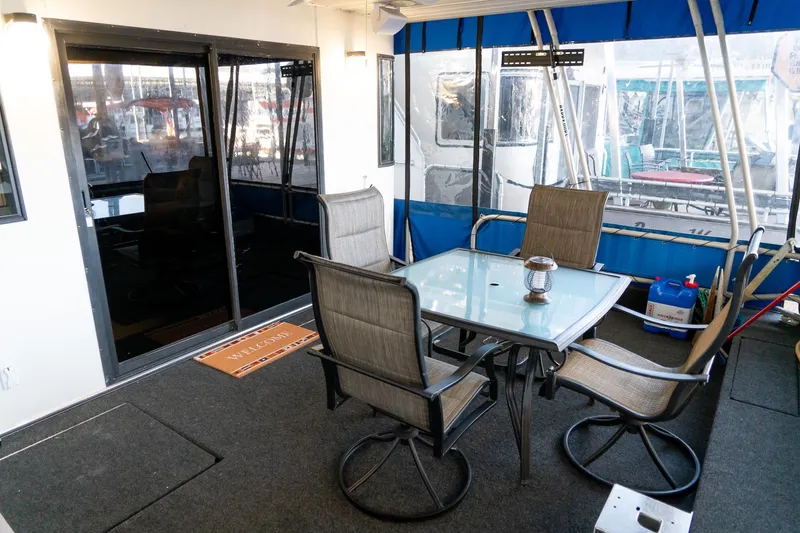 Slide: The Image of Outdoor seating area on 1996 Lakeview 66 x 16 Widebody Houseboat with glass table and chairs. - 19