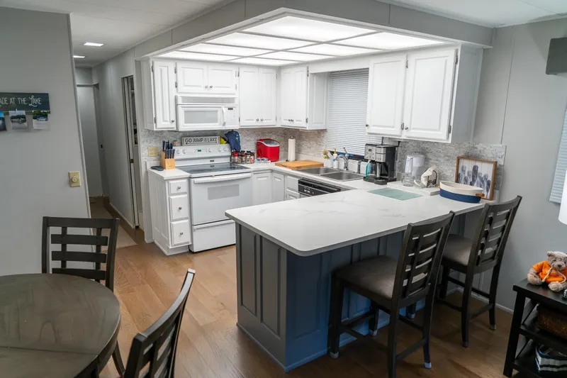 Slide: The Image of Modern kitchen in 1996 Lakeview 66 x 16 Widebody Houseboat with white cabinets and island. - 24