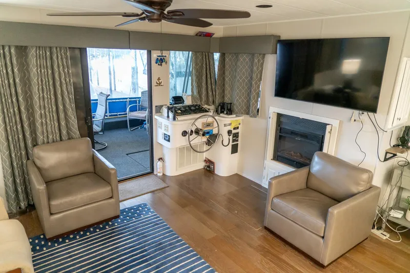 Slide: The Image of 1996 Lakeview 66 x 16 Widebody Houseboat interior with modern living area and large TV. - 26