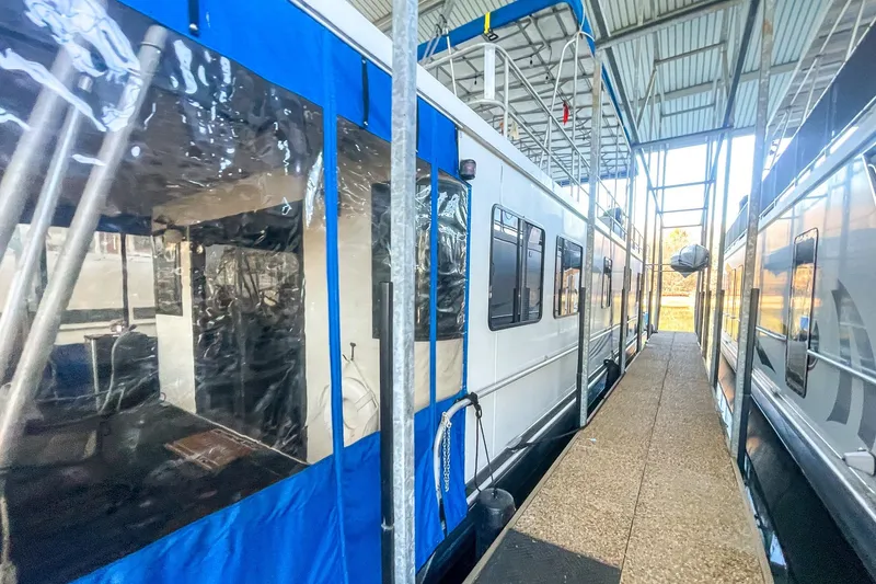 Slide: The Image of 1996 Lakeview 66 x 16 Widebody Houseboat docked in a covered marina. - 3
