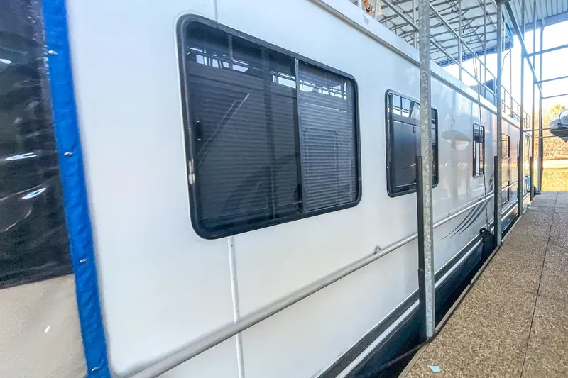 Slide: The Image of 1996 Lakeview 66 x 16 Widebody Houseboat docked in a marina. - 4