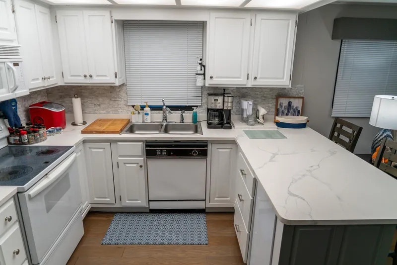 Slide: The Image of Modern kitchen in a 1996 Lakeview 66 x 16 Widebody Houseboat with white cabinets and appliances. - 40