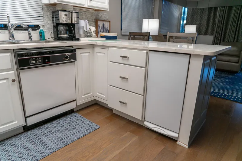 Slide: The Image of Modern kitchen interior on 1996 Lakeview 66 x 16 Widebody Houseboat, featuring white cabinetry. - 44