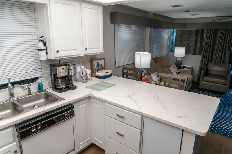 Slide: The Image of Modern kitchen and living area in 1996 Lakeview houseboat, featuring white cabinetry and cozy seating. - 45
