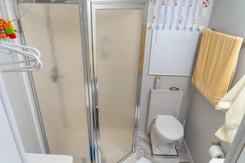Slide: The Image of Bathroom in 1996 Lakeview houseboat with shower, toilet, and yellow towel. - 48