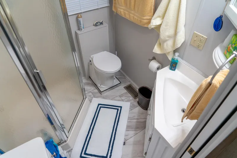 Slide: The Image of Compact bathroom in 1996 Lakeview 66 x 16 Widebody Houseboat with shower, toilet, and sink. - 49