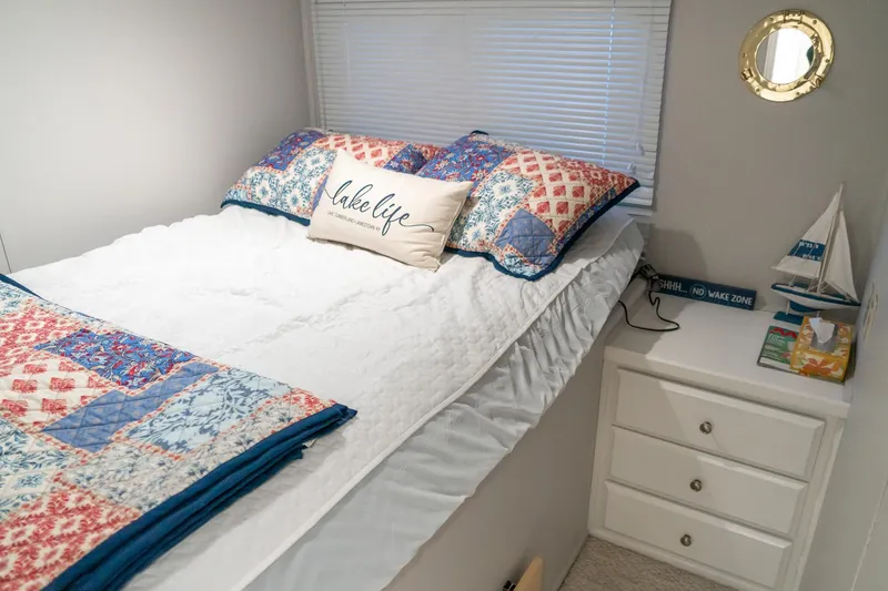 Slide: The Image of Cozy bedroom in 1996 Lakeview houseboat with nautical decor and colorful bedding. - 51