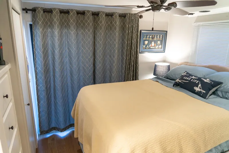 Slide: The Image of Cozy bedroom in 1996 Lakeview houseboat with nautical decor and ceiling fan. - 61