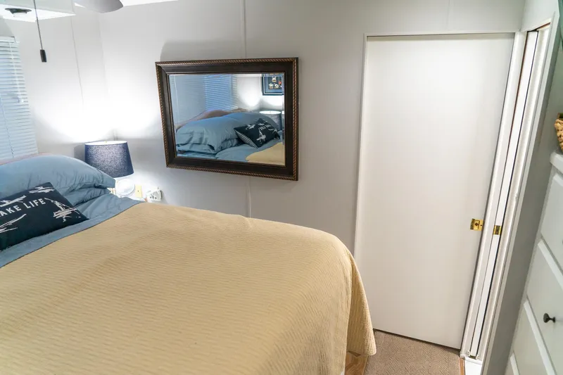 Slide: The Image of Cozy bedroom in 1996 Lakeview houseboat with mirror, lamp, and nautical decor. - 66